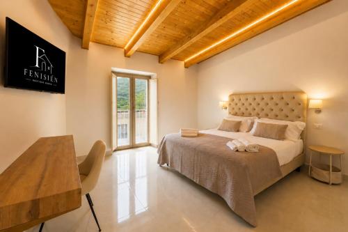 a bedroom with a large bed and a table at Fenisien Boutique Rooms in Contursi