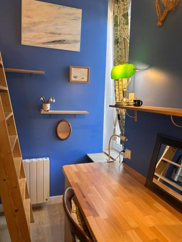 a dining room with blue walls and a wooden table at studio 25 in Dinard