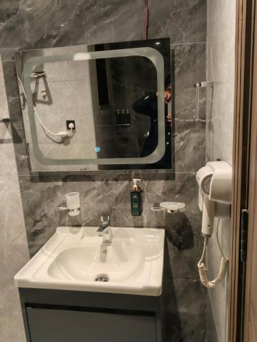 a bathroom with a sink and a mirror at Park Ridge Hotel Serviced Apartments - Executive Apartment in Murree