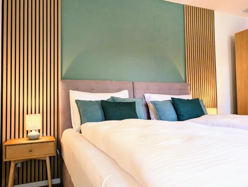 a bedroom with a large white bed with blue pillows at HabeDere Apartments Allgäu in Obergünzburg