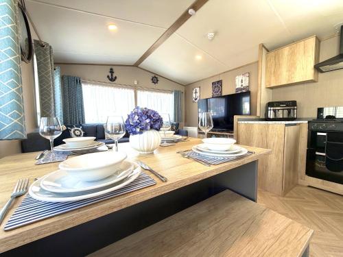 a kitchen with a table with plates and wine glasses at Gordy's Nook in Scarborough
