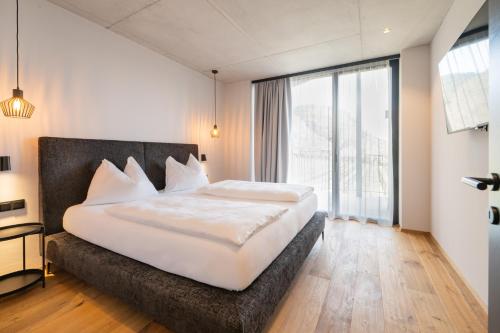 a bedroom with a large bed and a large window at View - AgriSuites in Caldaro