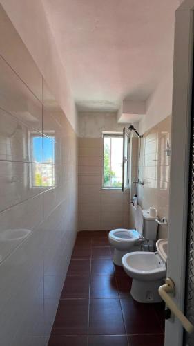 a bathroom with two sinks and two toilets at Cozzy Studio Flat in Tirana