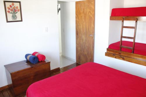 1 dormitorio con cama roja y manta roja en Apartamento El Calvario 4 en Tandil
