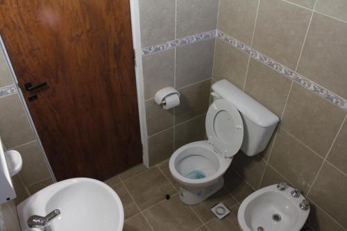 y baño con aseo y lavamanos. en Apartamento El Calvario 4 en Tandil