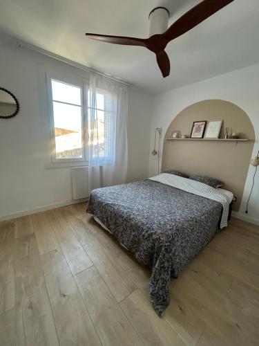 a bedroom with a bed and a ceiling fan at Maison de village la digue in Fabrègues