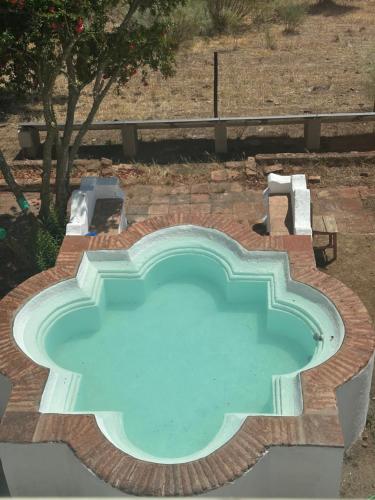 a large swimming pool with a table and chairs around it at Herdade Monte da Tapada in Alqueva