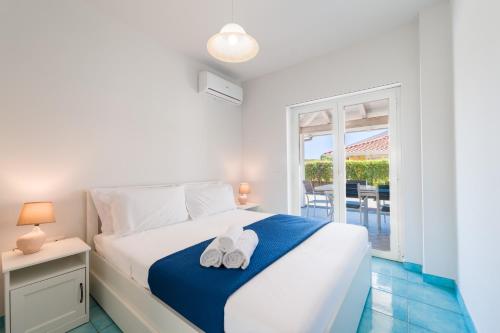 a bedroom with a bed with two white shoes on it at CalaDune Villas in Pizzo