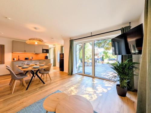 a kitchen and living room with a table and chairs at HabeDere Apartments Allgäu in Obergünzburg