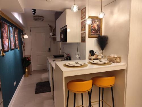 a kitchen with two stools at a kitchen counter at CA Smart Staycation at Azure North in Lagundi