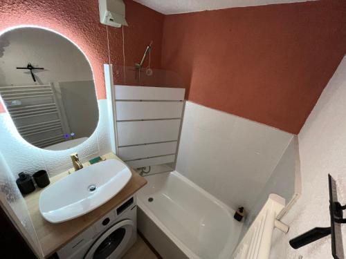a bathroom with a sink and a toilet and a mirror at EcrAin Montagnard in Lélex