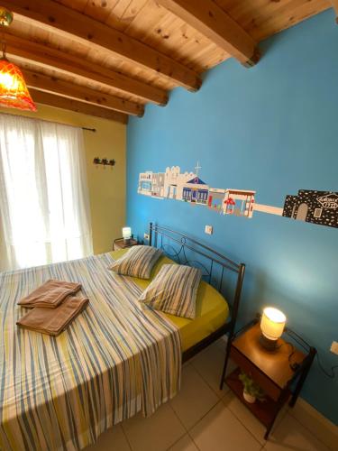 a bedroom with a bed and a blue wall at Roxys sea view Santorini Monolithos in Santorini