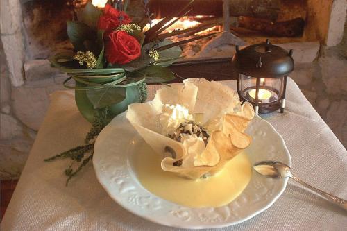 a white plate with a dessert on a table at LOGIS Hôtel Le Chantoiseau in Chaumont-sur-Aire