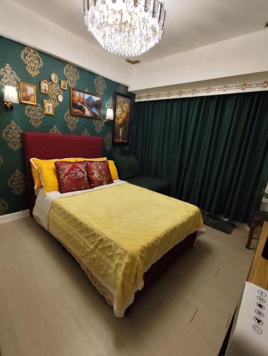 a bedroom with a bed and a chandelier at CA Smart Staycation at Azure North in Lagundi