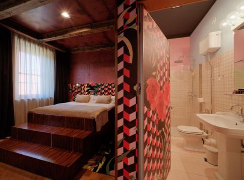 a bedroom with a bed and a bathroom at ROXANICH Winery and Design Hotel in Motovun