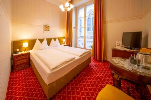 ein Hotelzimmer mit Bett und Fernseher in der Unterkunft Hotel Austria - Wien in Wien
