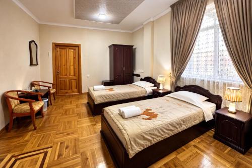 a hotel room with two beds and a window at Hotel Latif Samarkand in Samarkand