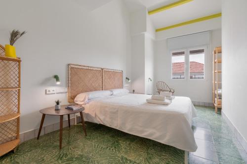 a white bedroom with a bed and a table at Raízes 22 - Apartamento 5 in Puebla de Don Fadrique