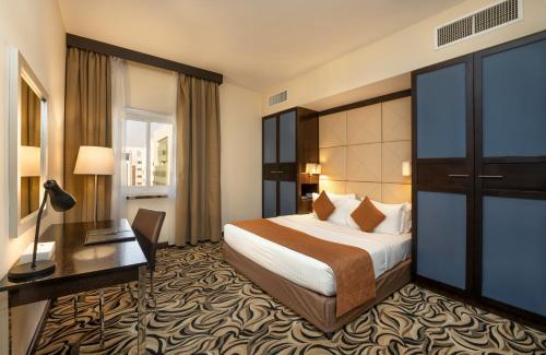 a hotel room with a bed and a desk at The Eclipse Boutique Suites in Abu Dhabi