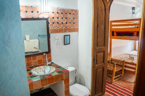 a bathroom with a sink and a toilet and a mirror at Riad Le Cheval Blanc in Safi
