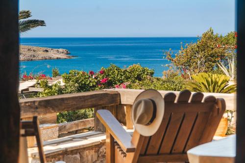 a chair sitting on a balcony with a view of the ocean at Terra Minoika Boutique Resort in Kato Zakros