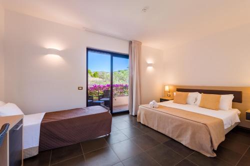 a hotel room with two beds and a balcony at Borgo Del Principe in Zambrone