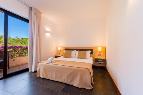 a bedroom with a large bed and a balcony at Borgo Del Principe in Zambrone