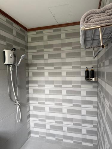 ein Badezimmer mit Dusche und grauen und weißen Fliesen in der Unterkunft Phines Place in Panglao