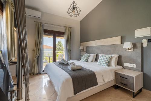a bedroom with a large bed and a large window at Meliton Inn Hotel & Suites by the beach in Neos Marmaras