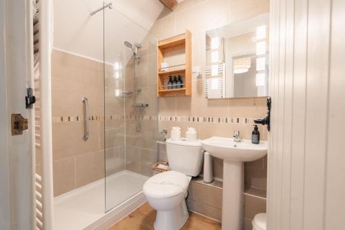 a bathroom with a toilet and a shower and a sink at Critchlow Cottage in Buxton