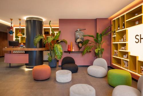a waiting room with colorful seating and plants at Aparthotel Colombo Roma in Rome