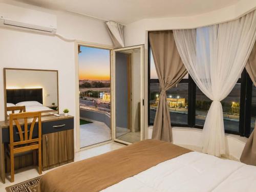 a bedroom with a bed and a large window at Lavanda Beach Resort in Abū Rudays