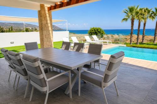 a dining table and chairs with a view of the ocean at Villa Celestia in Neo Chorio