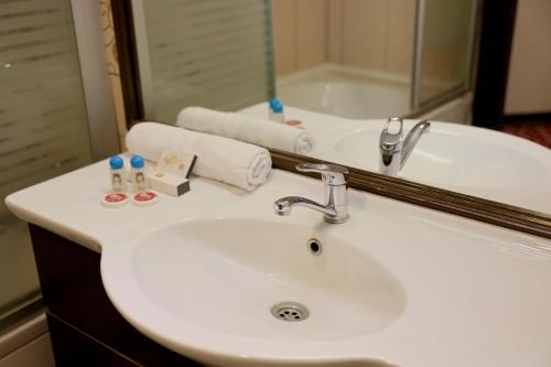a white sink in a bathroom with a mirror at Akyuz Hotel in Ankara