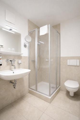 a bathroom with a shower and a sink and a toilet at Motel Smart in Bogen