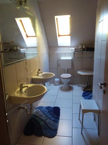 a bathroom with three sinks and a toilet at Castelinho Apartmanház in Gyenesdiás