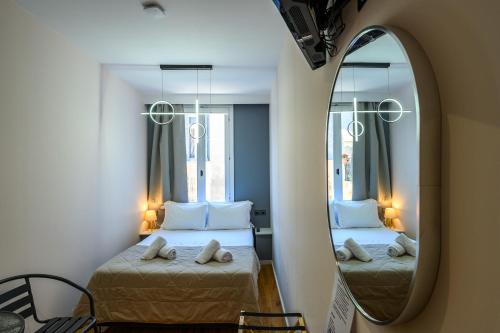 a bedroom with two beds and a mirror at Swan Paradise Nafplio in Nafplio