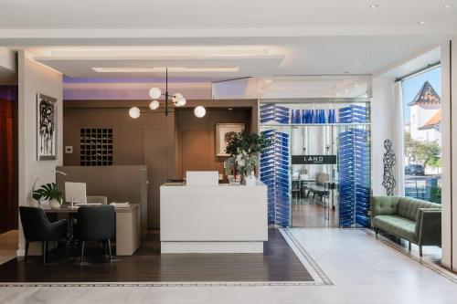 a lobby of a hotel with a reception desk and chairs at MiM Sitges member of Meliá Collection in Sitges