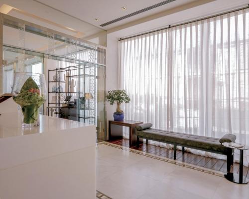 a living room with a bench in front of a large window at MiM Sitges member of Meliá Collection in Sitges