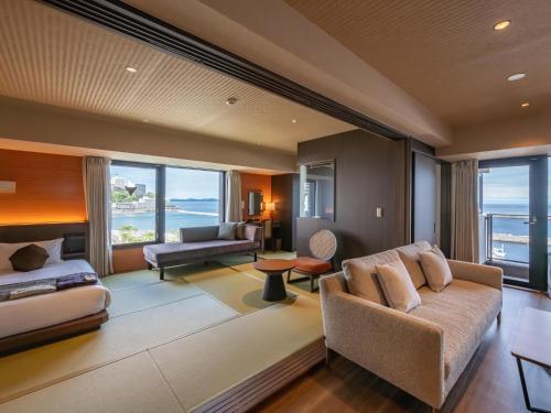 a living room with a couch and a table at Atami Hotel Nagisakan in Atami