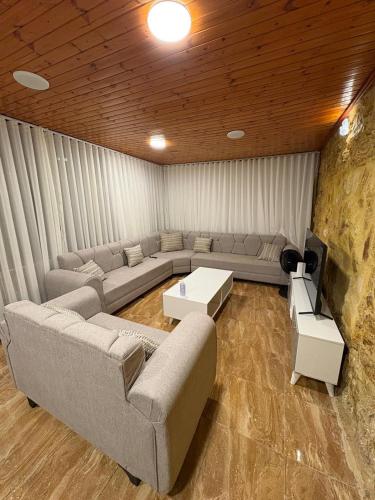 a living room with a couch and a tv in it at Cozy farm in Jerash