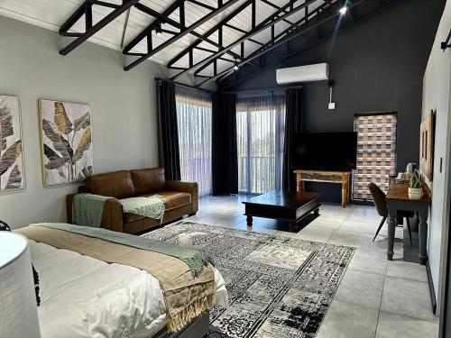 a bedroom with a bed and a living room with a piano at Fairview Guest House Executive in Hartswater