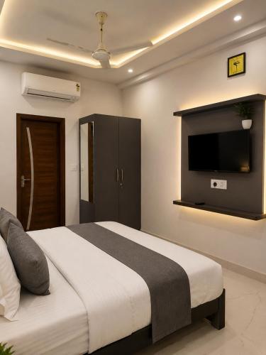a bedroom with a large bed with a flat screen tv at Landmark Hotel in Jodhpur