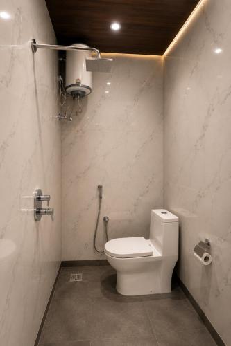 a bathroom with a white toilet and a sink at Landmark Hotel in Jodhpur