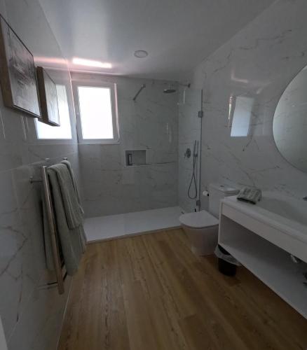 a white bathroom with a tub and a sink at RR Pico in São Mateus