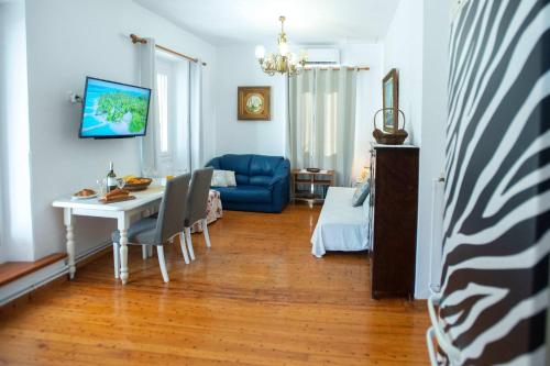 a living room with a table and a blue couch at Casa Sulla Montagna North Corfu in Loútsai