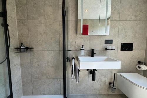 a bathroom with a sink and a shower at Relax Apartment Lakewalk in Friedrichshafen