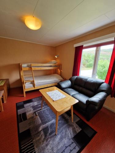 a living room with a couch and a bunk bed at Skorovas Fjellstue in Namsskogan