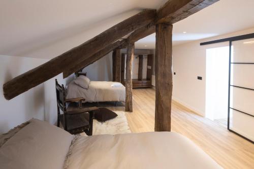 a bedroom with a bed in a room with wooden beams at El Rincón de Julia in Carrión de los Condes