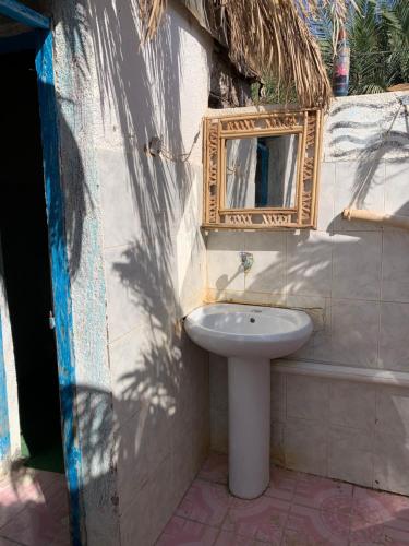 a bathroom with a sink and a mirror on the wall at kalima camp in Nuweiba‘ el Muzeinah